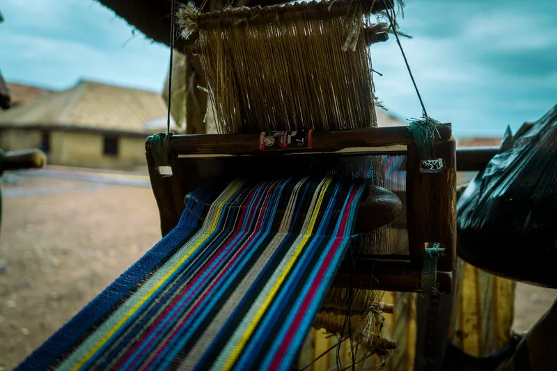 Colourful threads being woven on a traditional handloom